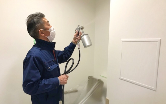 建物の内装壁面に光触媒コーティング「サンライト」を施しているスタッフ