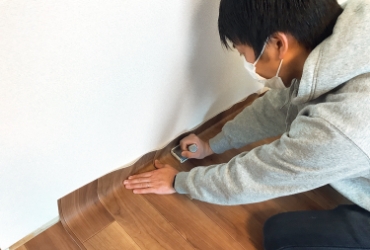 床面に木目のシート貼るようす