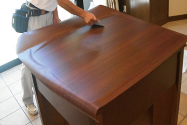 建具に木目のシートを張り替えているようす