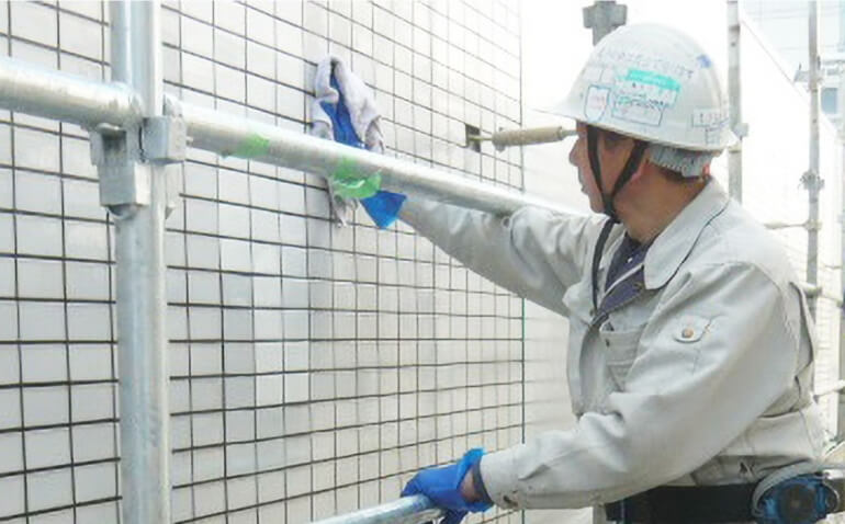 タイル壁面の塗装工事を行う職人